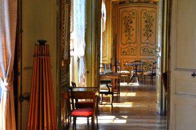 Façade d'un grand bâtiment ancien éclairé la nuit, entouré de petites lumières au sol.