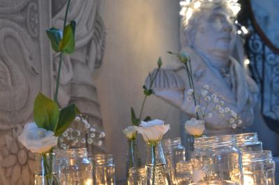 Façade d'un grand bâtiment ancien éclairé la nuit, entouré de petites lumières au sol.