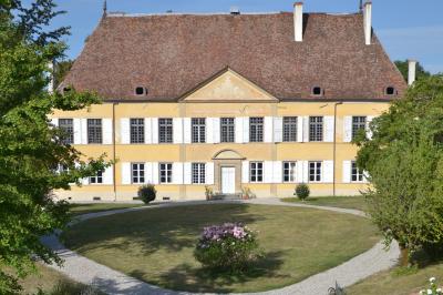 Façade d'un grand bâtiment ancien éclairé la nuit, entouré de petites lumières au sol.