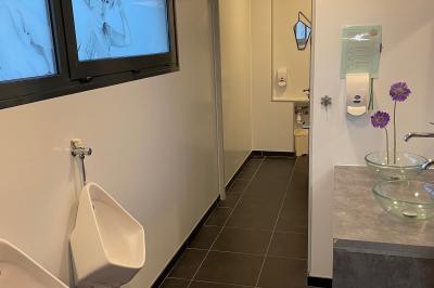 Miniature Location salle Lanrivoaré (Finistère) - L'Elegante #11 Salle vide avec sol gris, murs blancs, tableau mural, grande fenêtre donnant sur une terrasse et un espace vert.