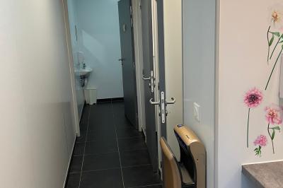 Miniature Location salle Lanrivoaré (Finistère) - L'Elegante #10 Salle vide avec sol gris, murs blancs, tableau mural, grande fenêtre donnant sur une terrasse et un espace vert.