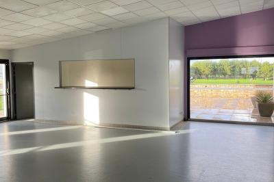Miniature Coin bar de la petite salle Salle vide avec sol gris, murs blancs, tableau mural, grande fenêtre donnant sur une terrasse et un espace vert.