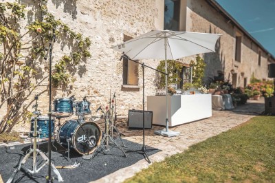 Miniature Location salle Aincourt (Val-d'Oise) - Domaine de Brunel - La Remise #9 Paysage champêtre avec un arbre pleureur, des fleurs bleues au premier plan et un champ sous un ciel partiellement nuageux.
