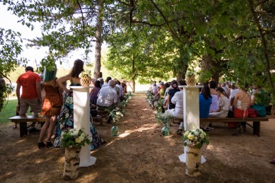 Tentes blanches pointues installées dans un jardin paysager avec vue sur une vallée boisée sous un ciel partiellement…