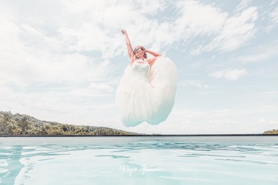 Tentes blanches pointues installées dans un jardin paysager avec vue sur une vallée boisée sous un ciel partiellement…