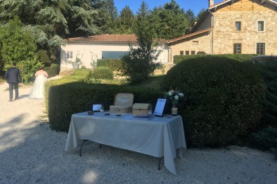Tentes blanches pointues installées dans un jardin paysager avec vue sur une vallée boisée sous un ciel partiellement…