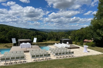 Salle de réception décorée avec des guirlandes lumineuses, des lampions suspendus et des tables dressées pour un événement.