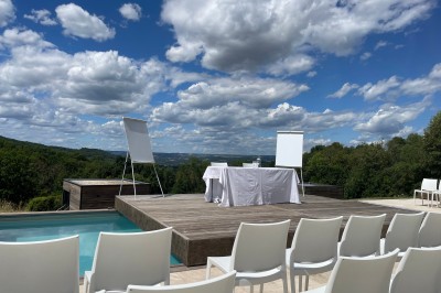 Salle de réception décorée avec des guirlandes lumineuses, des lampions suspendus et des tables dressées pour un événement.