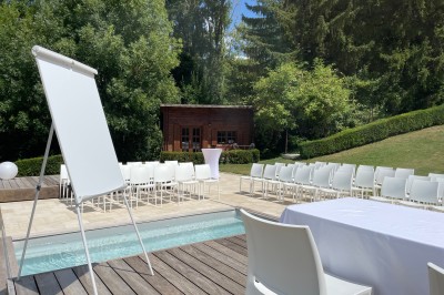 Salle de réception décorée avec des guirlandes lumineuses, des lampions suspendus et des tables dressées pour un événement.