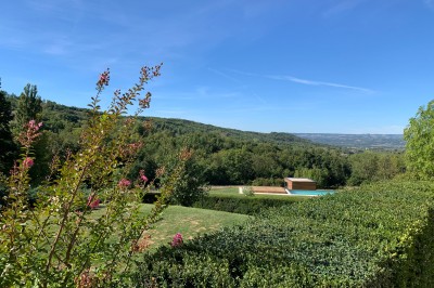 Salle de réception décorée avec des guirlandes lumineuses, des lampions suspendus et des tables dressées pour un événement.