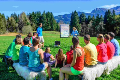 Salle de réception décorée avec des guirlandes lumineuses, des lampions suspendus et des tables dressées pour un événement.
