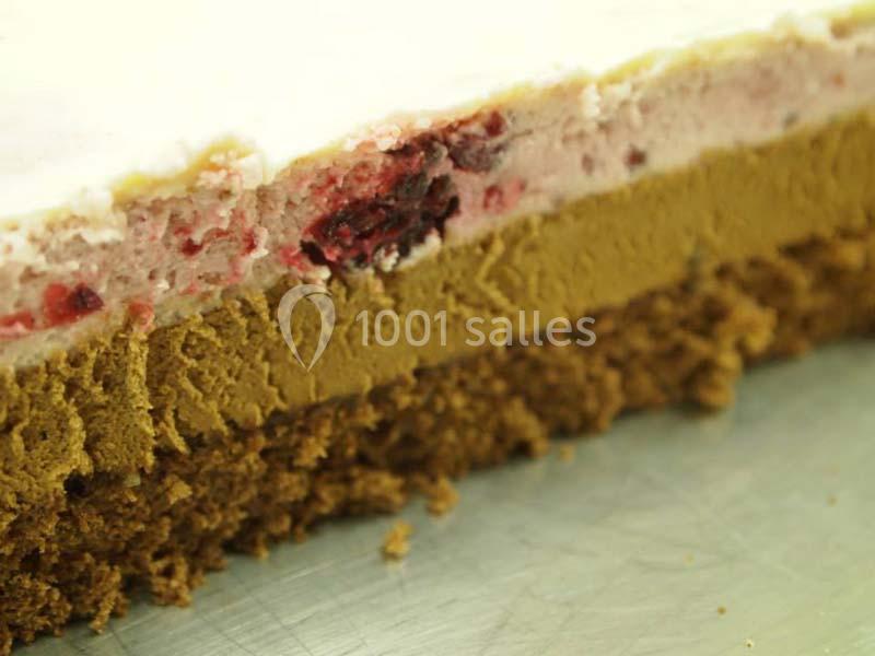 Gros plan sur les couches d'un gâteau : biscuit, mousse au chocolat et mousse aux fruits rouges avec glaçage clair.