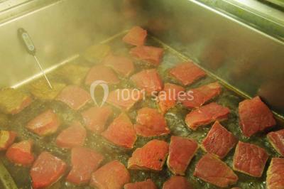 Pièce montée en forme de moto, composée de choux et nougatine, présentée sur une table dans une salle.
