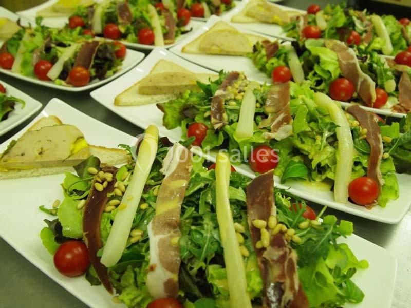 Assiettes de salade garnies de magret de canard, asperges, tomates cerises, pignons de pin et toasts au foie gras.