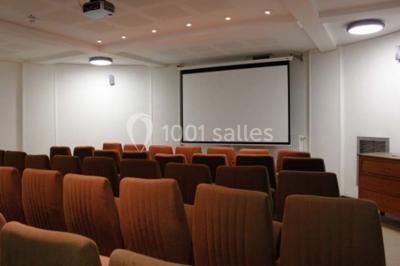 Banc en pierre au premier plan dans une allée bordée d'arbres, avec des promeneurs visibles au loin.