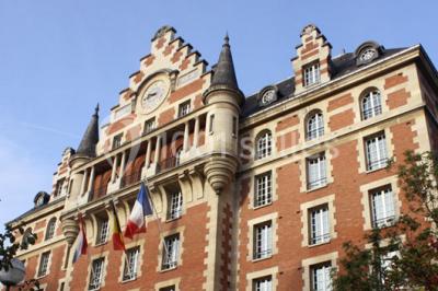 Banc en pierre au premier plan dans une allée bordée d'arbres, avec des promeneurs visibles au loin.