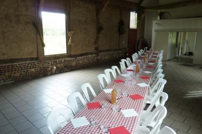 Miniature Location salle Montivilliers (Seine-Maritime) - Ferme d'Epaville #12 Salle rustique avec murs en pierre et poutres apparentes, aménagée avec tables hautes, canapés et décorations simples.