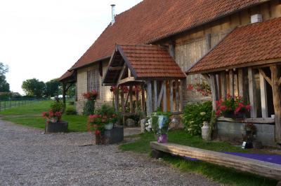 Miniature Location salle Montivilliers (Seine-Maritime) - Ferme d'Epaville #2 Salle rustique avec murs en pierre et poutres apparentes, aménagée avec tables hautes, canapés et décorations simples.