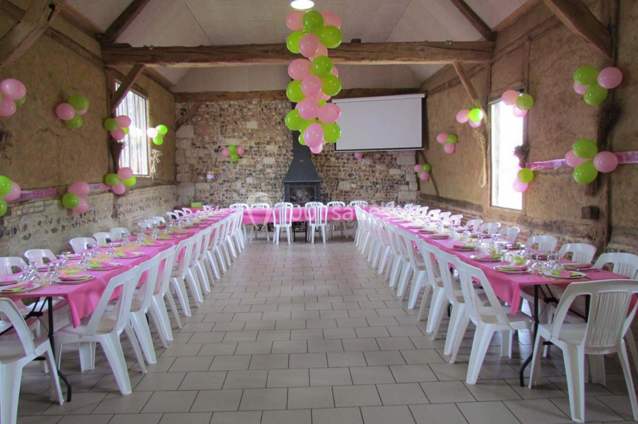 Location salle Montivilliers (Seine-Maritime) - Ferme d'Epaville #18 Salle de réception décorée avec des ballons roses et verts, tables alignées avec nappes roses et chaises blanches.