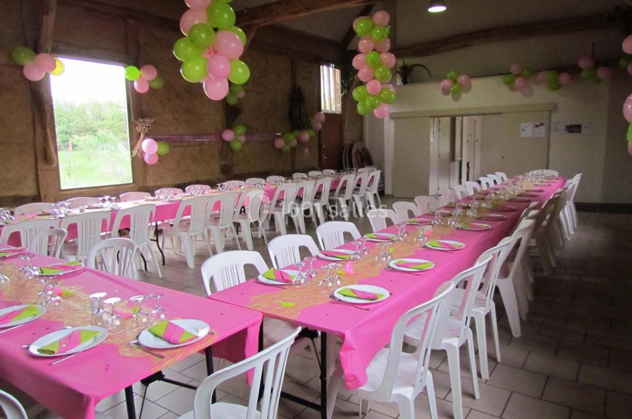 Location salle Montivilliers (Seine-Maritime) - Ferme d'Epaville #23 Salle décorée pour une fête avec des tables alignées, nappes roses, vaisselle dressée et ballons roses et verts.