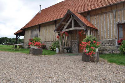 Miniature Location salle Montivilliers (Seine-Maritime) - Ferme d'Epaville #30 Salle rustique avec murs en pierre et poutres apparentes, aménagée avec tables hautes, canapés et décorations simples.