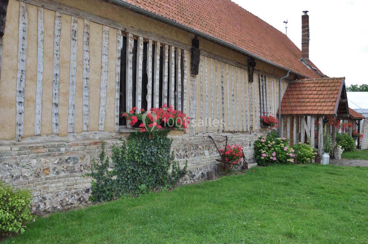 Location salle Montivilliers (Seine-Maritime) - Ferme d'Epaville #35 Façade d'une maison à colombages avec des fleurs en jardinières, un toit en tuiles et un jardin verdoyant.