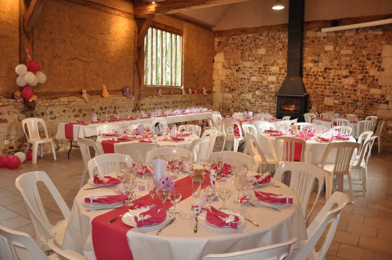 Location salle Montivilliers (Seine-Maritime) - Ferme d'Epaville #13 Salle décorée pour une réception, avec des tables rondes dressées, nappes blanches et chemins de table roses.