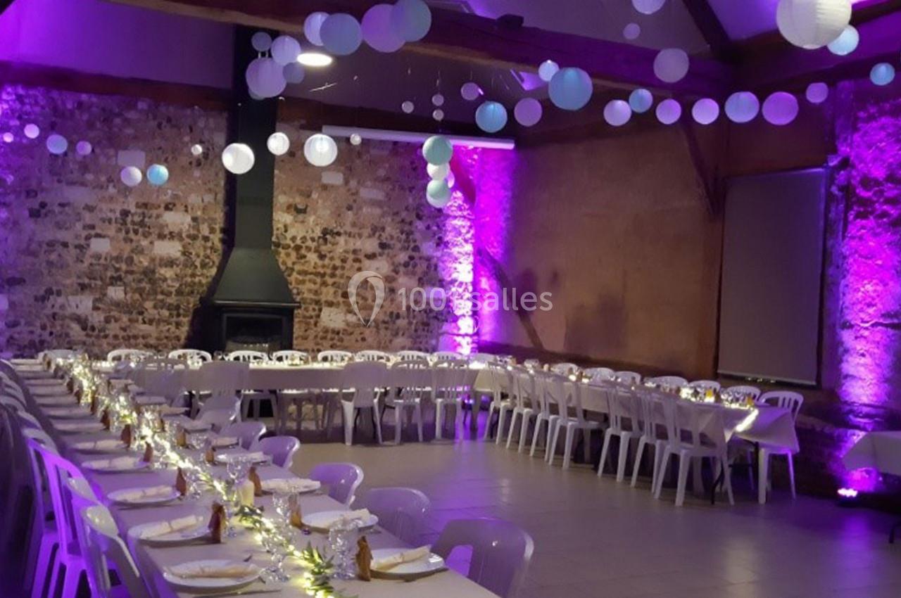 Location salle Montivilliers (Seine-Maritime) - Ferme d'Epaville #10 Salle de réception décorée avec des guirlandes lumineuses, des lanternes suspendues et des tables alignées pour un événement.