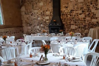 Miniature Location salle Montivilliers (Seine-Maritime) - Ferme d'Epaville #8 Salle rustique avec murs en pierre et poutres apparentes, aménagée avec tables hautes, canapés et décorations simples.