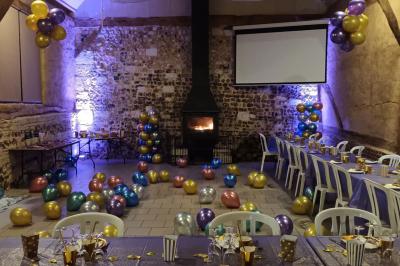 Miniature Location salle Montivilliers (Seine-Maritime) - Ferme d'Epaville #28 Salle rustique avec murs en pierre et poutres apparentes, aménagée avec tables hautes, canapés et décorations simples.