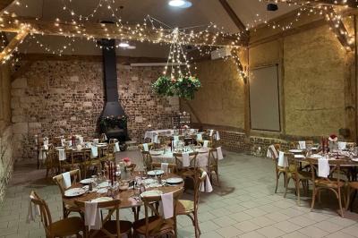 Miniature Location salle Montivilliers (Seine-Maritime) - Ferme d'Epaville #3 Salle rustique avec murs en pierre et poutres apparentes, aménagée avec tables hautes, canapés et décorations simples.