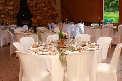 Miniature Location salle Montivilliers (Seine-Maritime) - Ferme d'Epaville #36 Grande table décorée pour un dîner, avec bougies et guirlandes lumineuses, dans une salle en pierres apparentes.