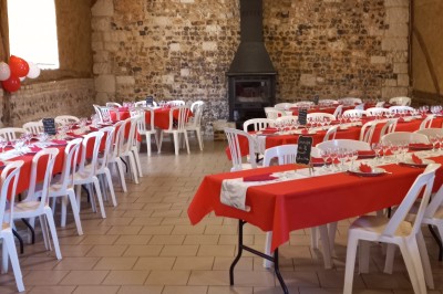 Miniature Location salle Montivilliers (Seine-Maritime) - Ferme d'Epaville #38 Grande table décorée pour un dîner, avec bougies et guirlandes lumineuses, dans une salle en pierres apparentes.