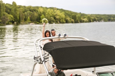 Cérémonie de mariage en plein air avec des invités assis, un couple avançant vers une arche décorée.