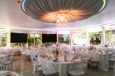 Cérémonie de mariage en plein air avec des invités assis, un couple avançant vers une arche décorée.