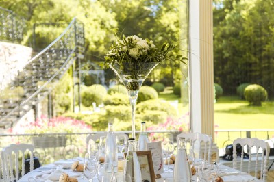 Cérémonie de mariage en plein air avec des invités assis, un couple avançant vers une arche décorée.