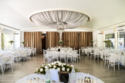 Cérémonie de mariage en plein air avec des invités assis, un couple avançant vers une arche décorée.
