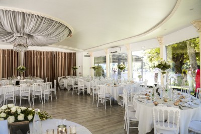 Cérémonie de mariage en plein air avec des invités assis, un couple avançant vers une arche décorée.