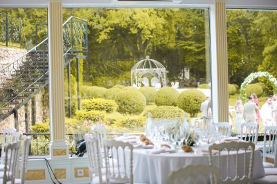 Cérémonie de mariage en plein air avec des invités assis, un couple avançant vers une arche décorée.