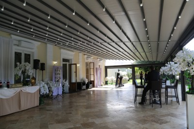 Miniature Location salle Le Coudray-Montceaux (Essonne) - Le Manoir des Cygnes #22 Des personnes discutent et se promènent le long d'une balustrade en fer forgé bordée de végétation, sous des arbres.