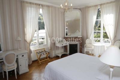 Cérémonie de mariage en plein air avec des invités assis, un couple avançant vers une arche décorée.