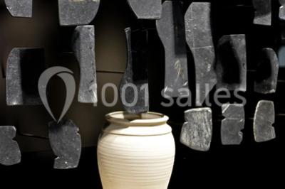 Rangée de limes métalliques suspendues avec des manches en bois dans un atelier ou une exposition artisanale.