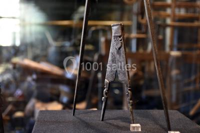 Rangée de limes métalliques suspendues avec des manches en bois dans un atelier ou une exposition artisanale.