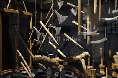 Rangée de limes métalliques suspendues avec des manches en bois dans un atelier ou une exposition artisanale.