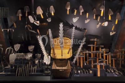 Rangée de limes métalliques suspendues avec des manches en bois dans un atelier ou une exposition artisanale.