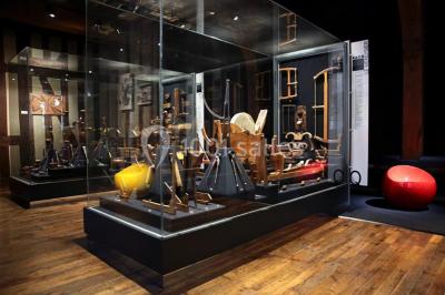 Rangée de limes métalliques suspendues avec des manches en bois dans un atelier ou une exposition artisanale.