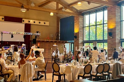 Un couple danse au centre d'une salle de réception éclairée par des lumières colorées et des étincelles.