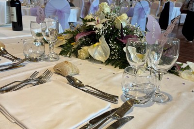Un couple danse au centre d'une salle de réception éclairée par des lumières colorées et des étincelles.
