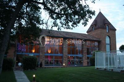 Un couple danse au centre d'une salle de réception éclairée par des lumières colorées et des étincelles.