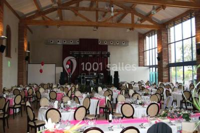 Un couple danse au centre d'une salle de réception éclairée par des lumières colorées et des étincelles.